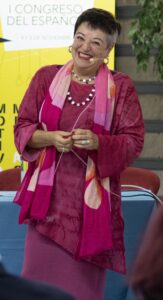 Foto de Concha en un escenario y con un microfono dando una charla y riendo